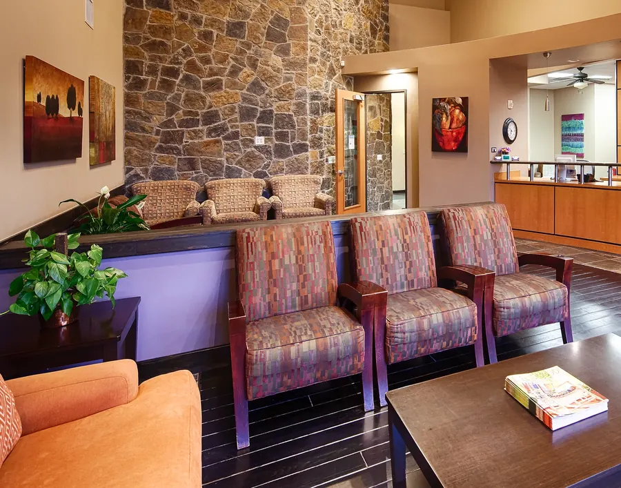 The waiting room, with its stone wall and armchairs.